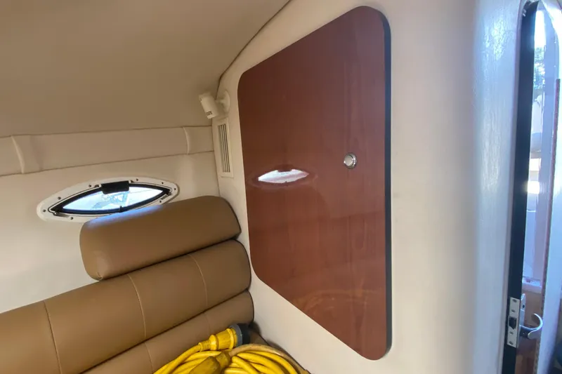 Slide: The Image of Interior of 2004 Monterey 245 Cruiser with tan seating and wooden paneling. - 22