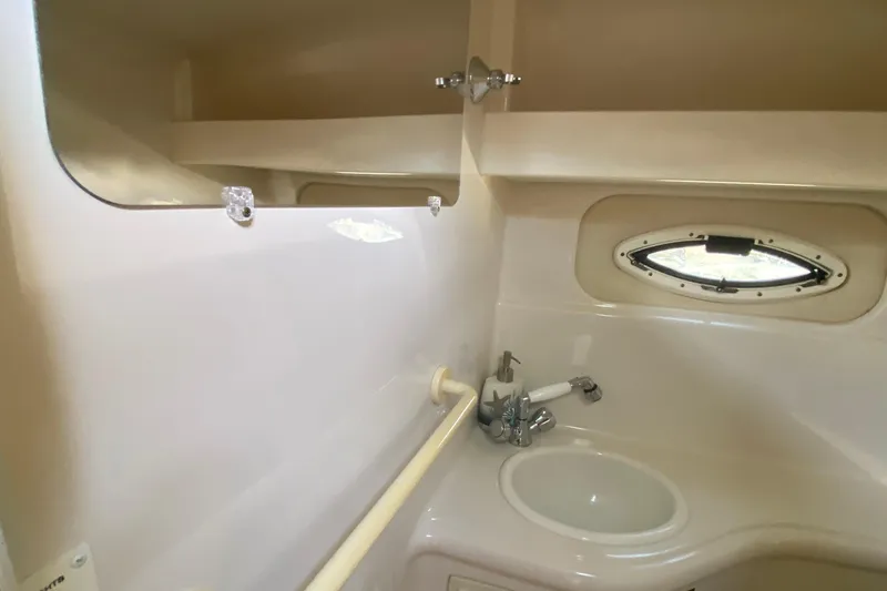 Slide: The Image of 2004 Monterey 245 Cruiser bathroom with sink, mirror, and oval window. - 24