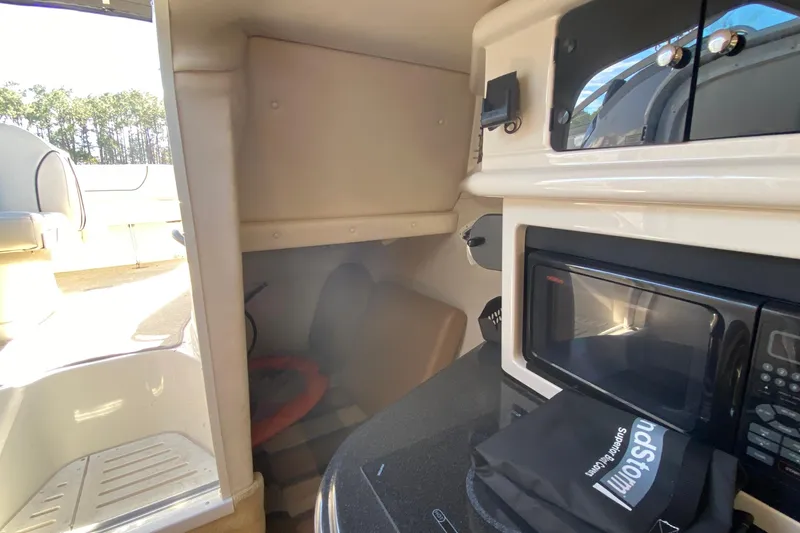 Slide: The Image of 2004 Monterey 245 Cruiser interior with microwave and storage area. - 26