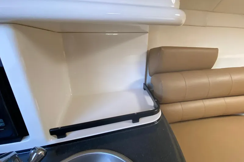 Slide: The Image of 2004 Monterey 245 Cruiser interior with beige seating and compact kitchenette. - 34