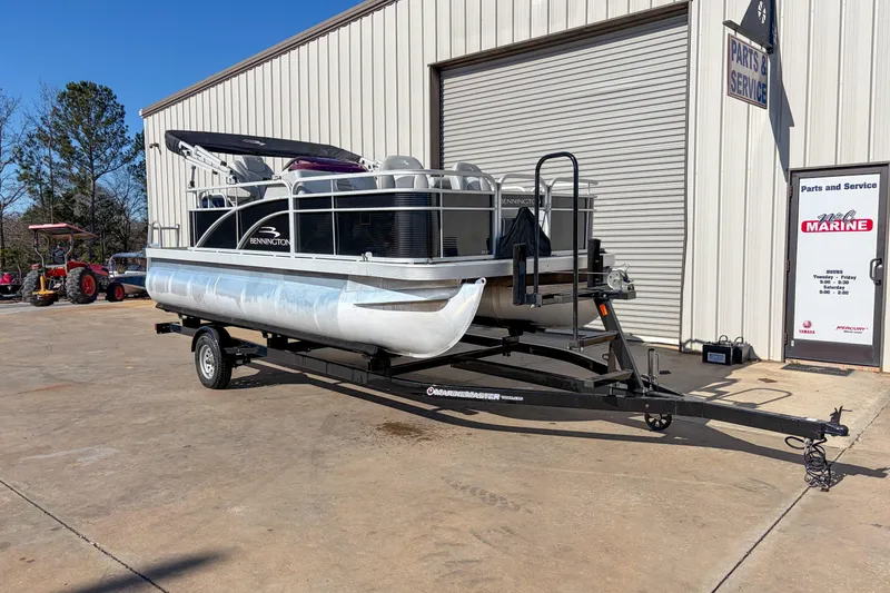 The Image of 2021 Bennington 188 SV pontoon boat on trailer outside service center. - 1