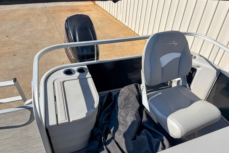 Slide: The Image of 2021 Bennington 188 SV boat interior with seating and motor, docked on concrete. - 13