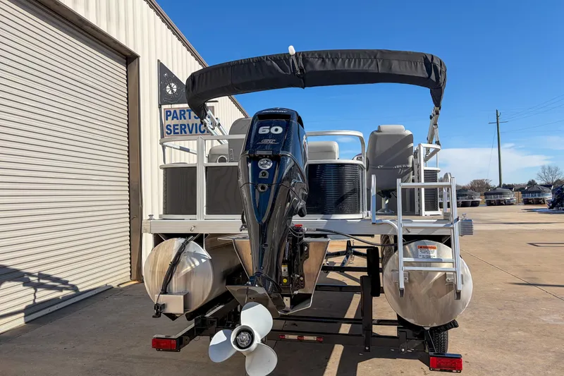 Slide: The Image of 2021 Bennington 188 SV pontoon boat with 60 HP engine, parked near service area. - 3