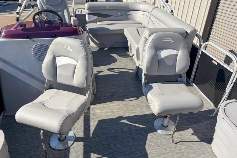 Slide: The Image of 2021 Bennington 188 SV pontoon boat interior with plush seating and steering console. - 6