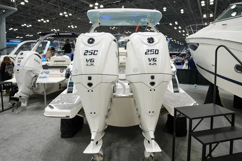 Slide: The Image of 2026 Regal LX9 boat with dual 250 V6 engines displayed at a boat show. - 1
