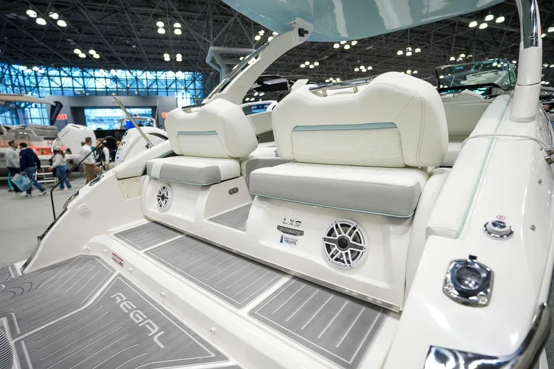 Slide: The Image of 2026 Regal LX9 luxury boat interior with plush seating and modern design at a boat show. - 2