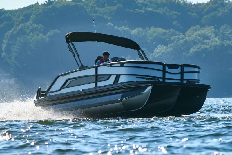 Slide: The Image of Manufacturer Provided Image: 2026 Evotti 721CS pontoon boat cruising on a scenic lake. - 2