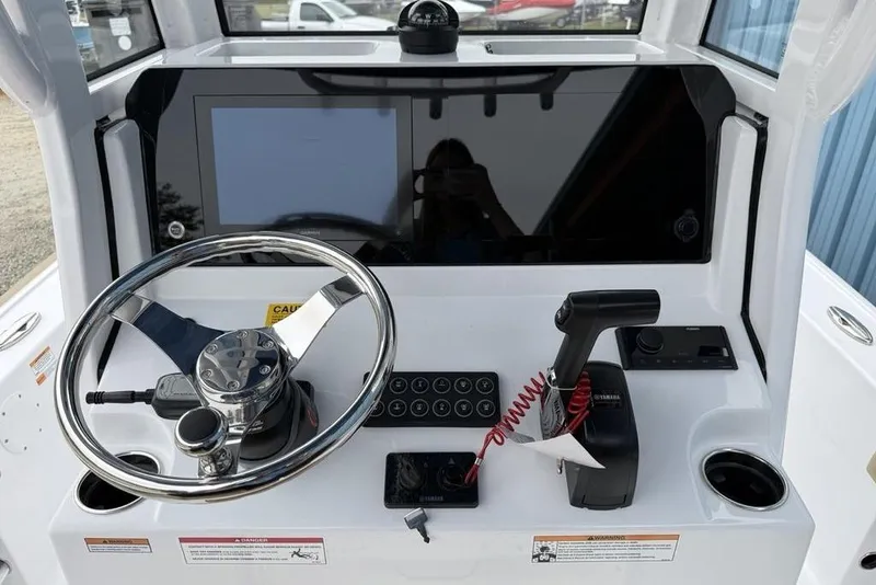 Slide: The Image of 2026 Sportsman Masters 227 Bay Boat dashboard with steering wheel and controls. - 17