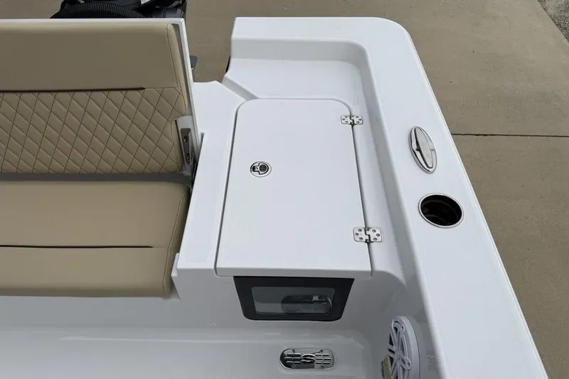 Slide: The Image of 2026 Sportsman Masters 227 Bay Boat interior with beige seating and storage compartment. - 25
