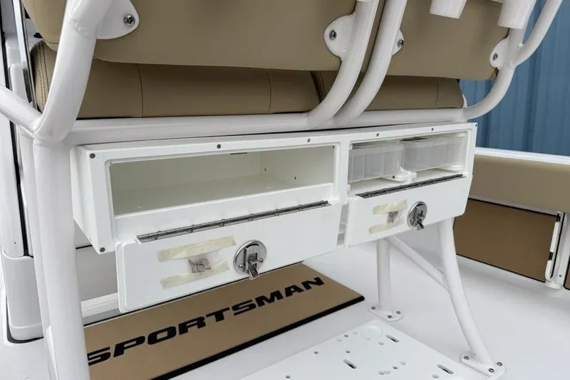 Slide: The Image of 2026 Sportsman Masters 227 Bay Boat storage compartments with beige seating and white frame. - 32