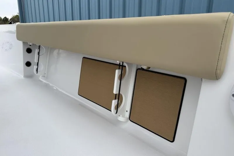 Slide: The Image of 2026 Sportsman Masters 227 Bay Boat interior with beige cushioned seating and storage compartments. - 33