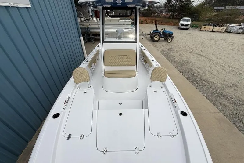 Slide: The Image of 2026 Sportsman Masters 227 Bay Boat with beige seating, docked near a blue building. - 39