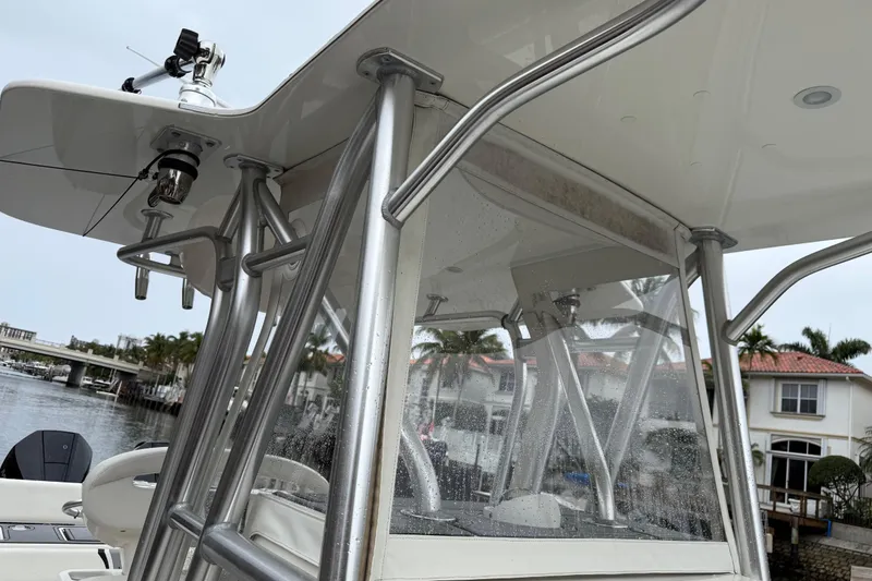 Slide: The Image of 2020 SeaVee 290B boat with stainless steel frame and clear enclosure, docked near waterfront homes. - 12