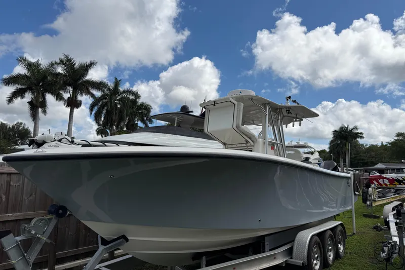 Slide: The Image of Twin Mercury 300 engines on a 2020 SeaVee 290B boat, docked on calm water. - 2