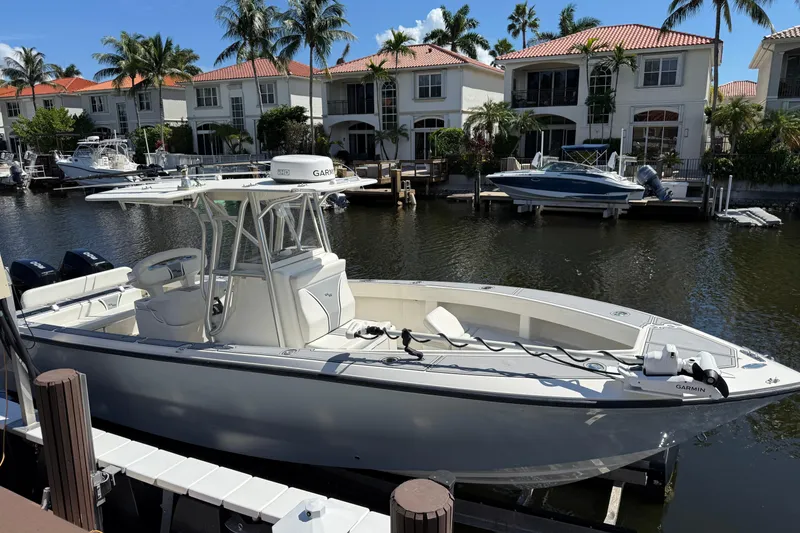 Slide: The Image of 2020 SeaVee 290B boat with dual Mercury outboard engines docked by a stone wall. - 3
