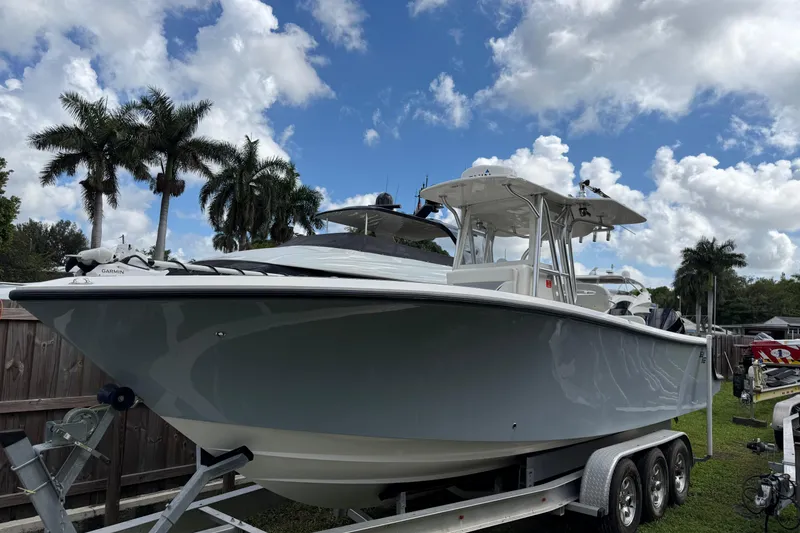 Slide: The Image of 2020 SeaVee 290B boat on trailer, surrounded by palm trees under a blue sky. - 31