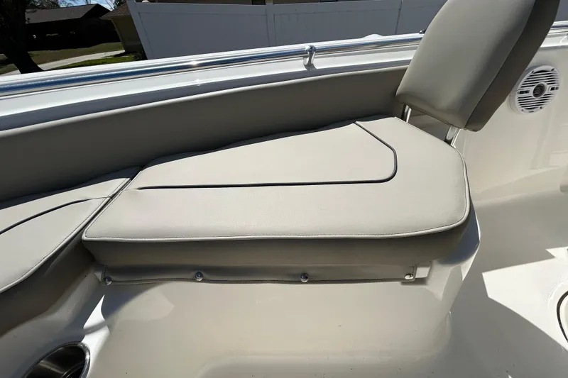 Slide: The Image of 2022 Key West 219 FS boat seat with light gray upholstery and cup holder. - 103