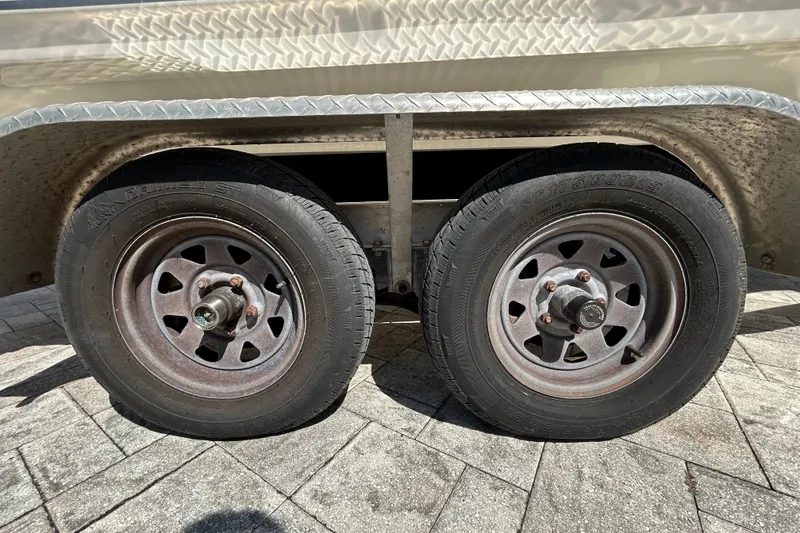Slide: The Image of Close-up of dual trailer wheels on a 2022 Key West 219 FS boat trailer. - 107
