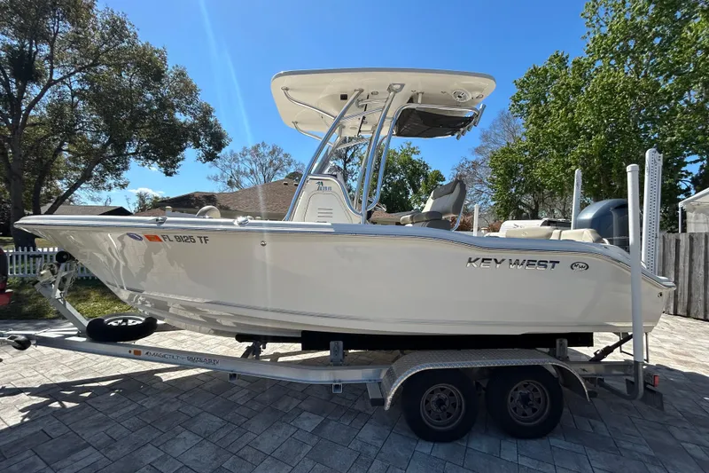 Slide: The Image of 2022 Key West 219 FS boat on trailer, parked outdoors on a sunny day. - 14