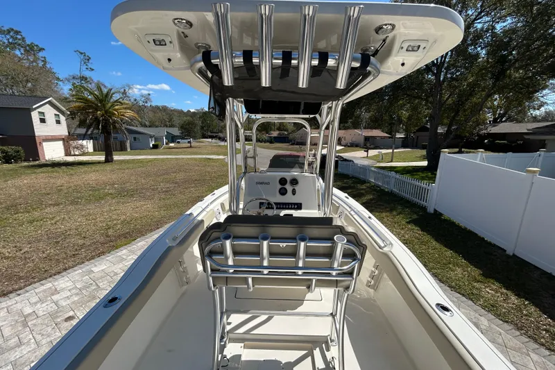 Slide: The Image of 2022 Key West 219 FS boat with T-top and rod holders, parked in a suburban neighborhood. - 22
