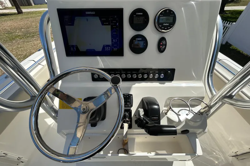 Slide: The Image of 2022 Key West 219 FS boat dashboard with steering wheel and navigation controls. - 28