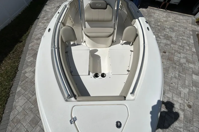 Slide: The Image of 2022 Key West 219 FS boat interior with seating and storage, parked on a paved driveway. - 38
