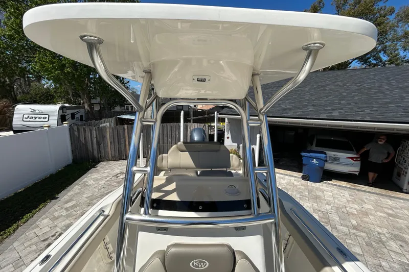 Slide: The Image of 2022 Key West 219 FS boat with T-top, parked in a driveway. - 45