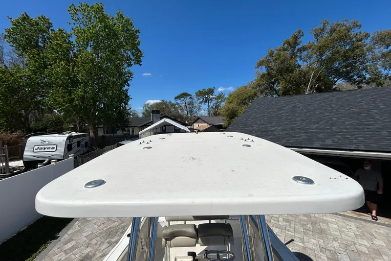 Slide: The Image of 2022 Key West 219 FS boat top view, parked in a driveway with trees and buildings. - 46