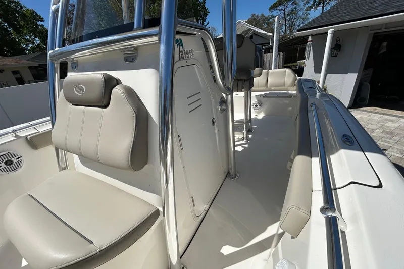 Slide: The Image of 2022 Key West 219 FS boat interior with beige seating and stainless steel railings. - 47