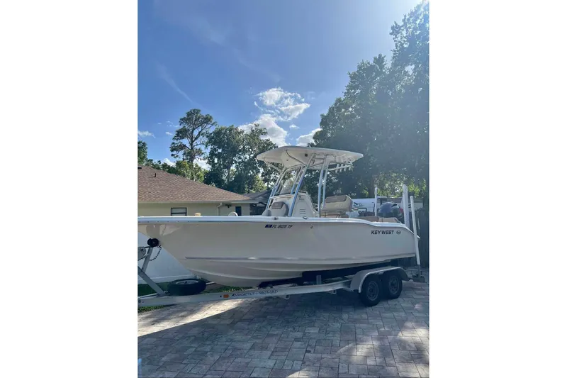 The Image of 2022 Key West 219 FS boat on trailer, parked outdoors under clear sky. - 5