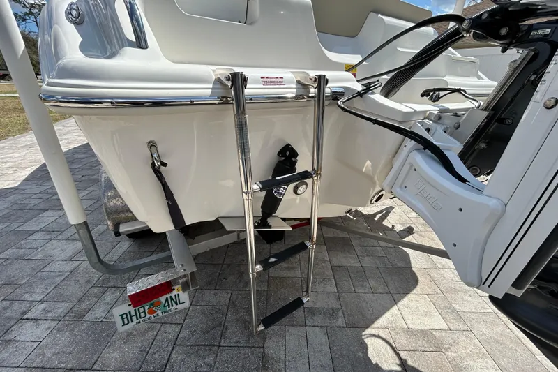 Slide: The Image of 2022 Key West 219 FS boat with ladder and trailer on paved surface. - 56