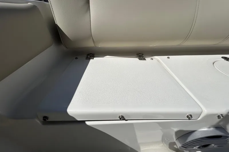 Slide: The Image of Interior seating of 2022 Key West 219 FS boat, featuring white cushioned seats and storage compartment. - 62