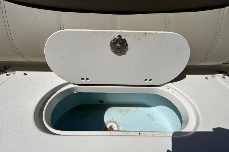 Slide: The Image of Open storage compartment on 2022 Key West 219 FS boat, featuring a white lid and interior. - 67