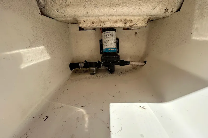 Slide: The Image of 2022 Key West 219 FS boat interior showing a Shurflo pump installation. - 72