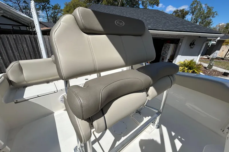 Slide: The Image of 2022 Key West 219 FS boat seat with beige upholstery and stainless steel frame. - 79