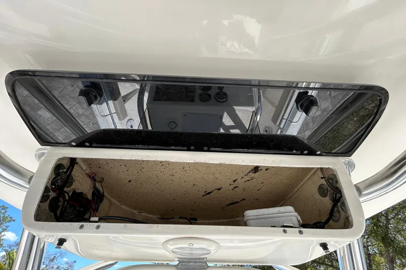 Slide: The Image of 2022 Key West 219 FS boat storage compartment with open lid and visible wiring. - 84