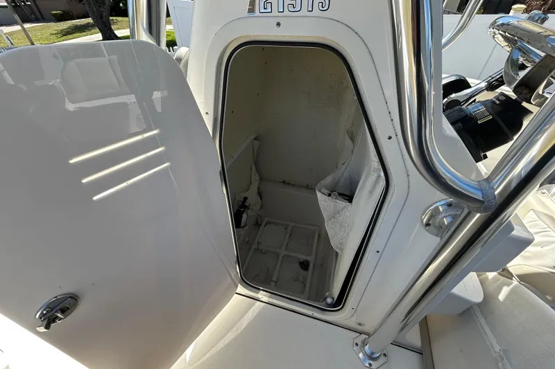 Slide: The Image of 2022 Key West 219 FS boat storage compartment with open door, showcasing interior space. - 87