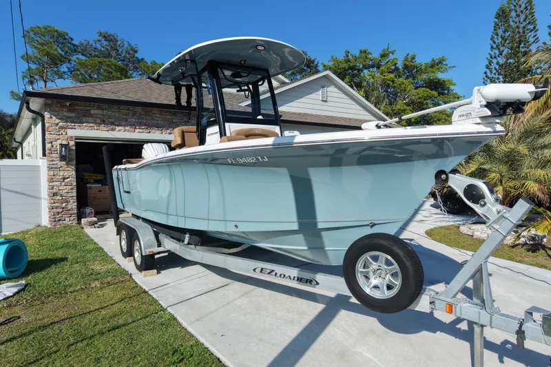 The Image of 2023 Sea Hunt Ultra 239 SE boat on trailer in driveway, sunny day. - 0