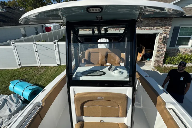 Slide: The Image of 2023 Sea Hunt Ultra 239 SE boat with tan seating and center console. - 10