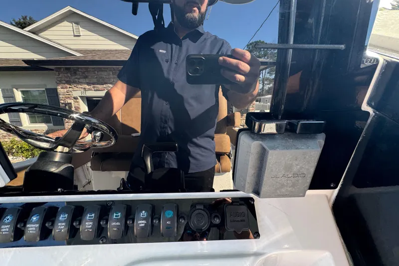 Slide: The Image of 2023 Sea Hunt Ultra 239 SE dashboard with steering wheel and JL Audio system. - 16