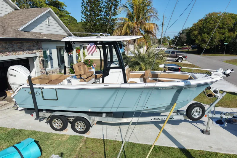 Slide: The Image of 2023 Sea Hunt Ultra 239 SE boat on trailer in residential driveway. - 2