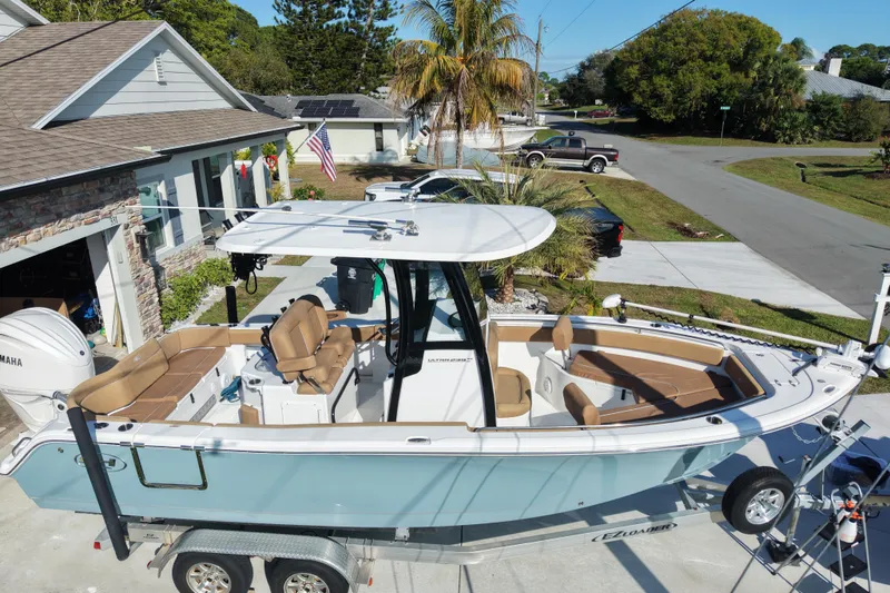 Slide: The Image of 2023 Sea Hunt Ultra 239 SE boat on trailer in residential driveway. - 23