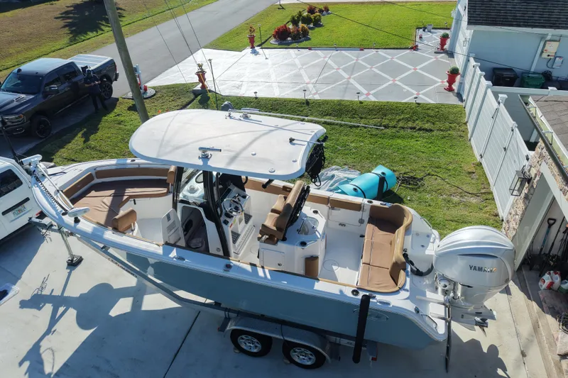 Slide: The Image of 2023 Sea Hunt Ultra 239 SE boat on trailer, parked in driveway, with Yamaha engine. - 26