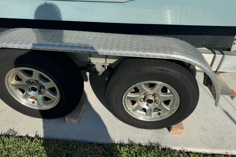 Slide: The Image of Trailer wheels of 2023 Sea Hunt Ultra 239 SE boat on concrete surface. - 30