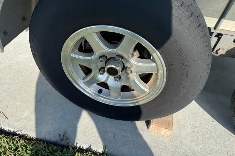 Slide: The Image of Trailer wheel of a 2023 Sea Hunt Ultra 239 SE on concrete surface. - 31