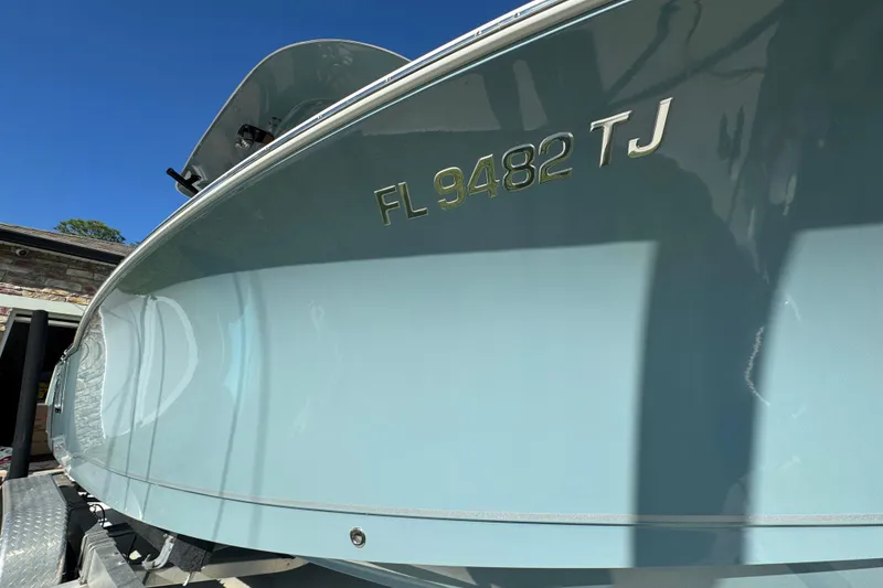 Slide: The Image of 2023 Sea Hunt Ultra 239 SE boat with registration FL 9482 TJ, docked under clear blue sky. - 6