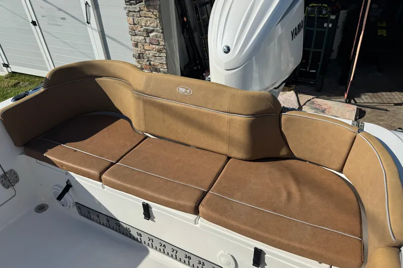 Slide: The Image of 2023 Sea Hunt Ultra 239 SE boat with tan cushioned seating and Yamaha engine. - 8