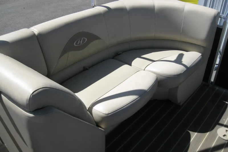 Slide: The Image of 2016 Harris FloteBote 200 Cruiser CX, beige boat seating, curved design, outdoor setting. - 14
