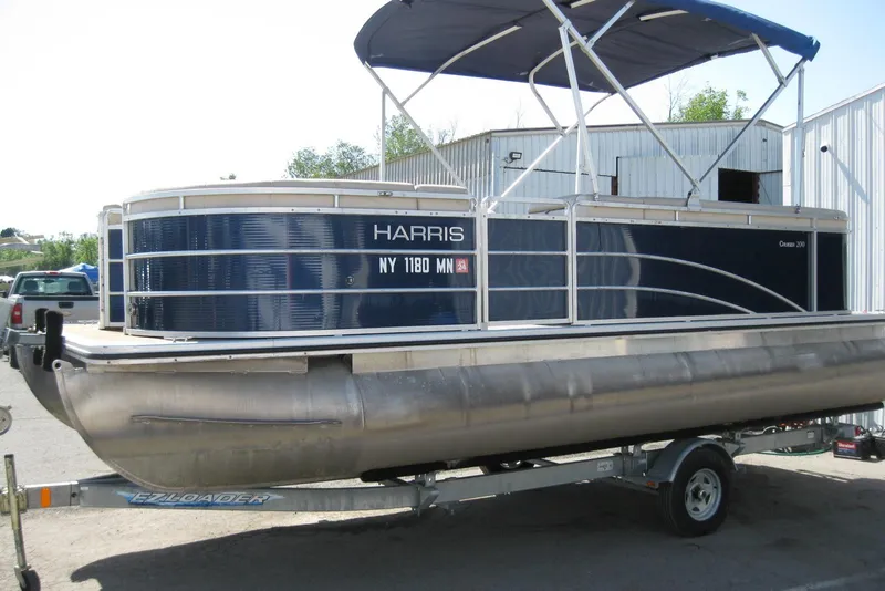 Slide: The Image of 2016 Harris FloteBote 200 Cruiser CX pontoon boat on trailer, blue exterior, docked outdoors. - 5