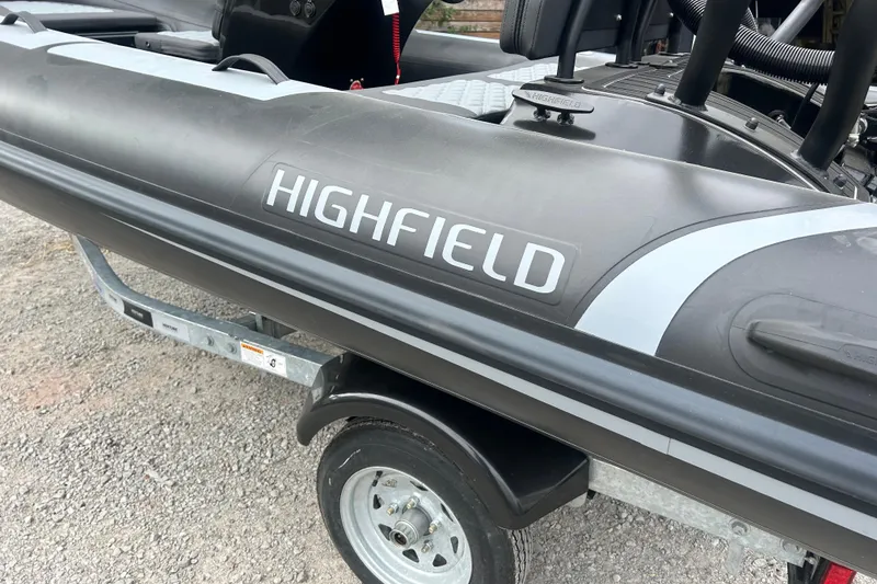 Slide: The Image of 2025 Highfield Sport 390 boat on trailer, showcasing sleek design and branding. - 7